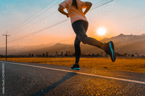 Asian woman enjoys running outside with beautiful summer evening in the countryside.