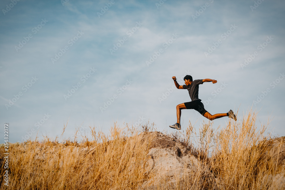 Image of Athlete trail running, runner running on hill.