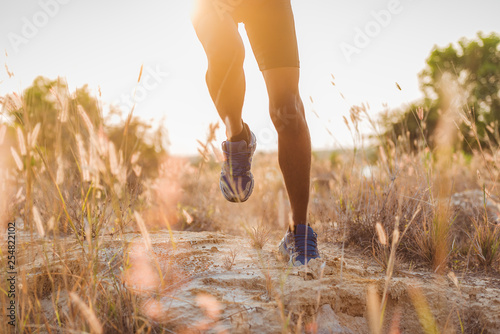 Image of Athlete trail running, runner running on hill.