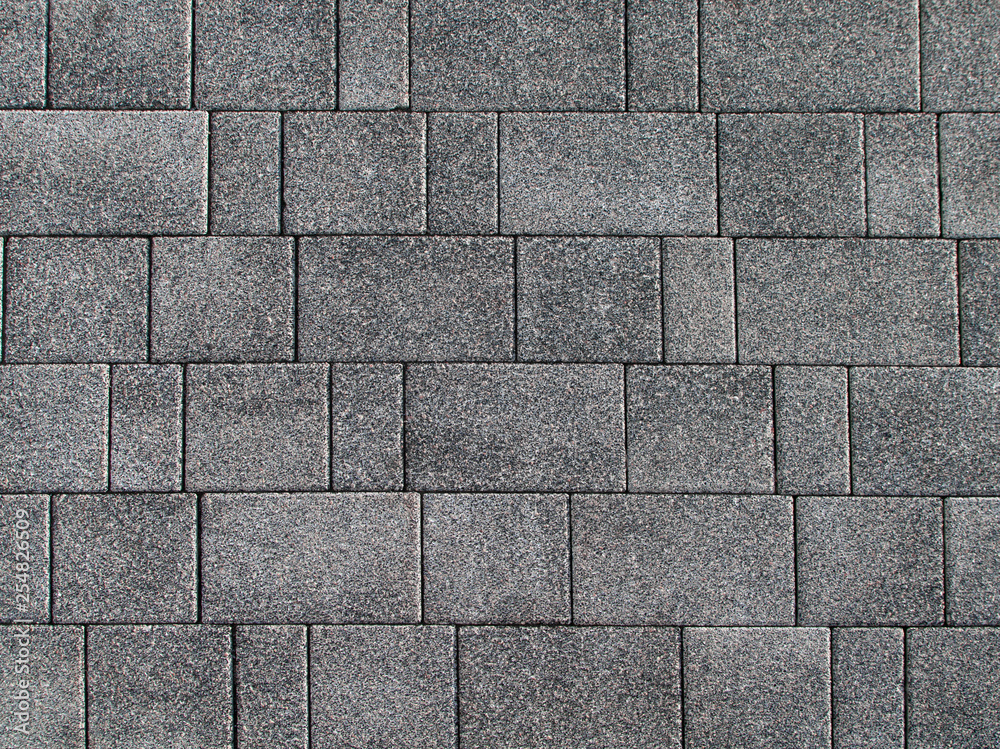 Fototapeta premium Background from a gray road rectangular tile with a small multi-colored crumb