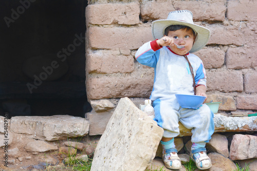 Latin toddler boy eating in the countryside.