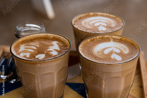 Cappuccinos served in glass tumblers.