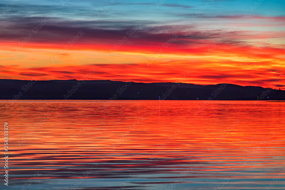 Stunning colorful red sunset at the sea with dramatic clouds