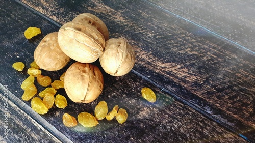 Three walnuts and a white isam lie on a wooden table. Still life. photo