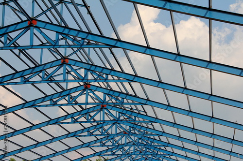 Structure of steel roof frame for building construction on sky background