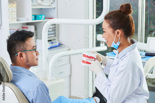 Dentist explaining patient's problem on teeth model