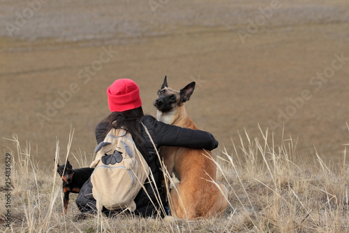 Obraz na płótnie The girl and dogs in the spring nature, the Belgian Shepherd Malinois breed and