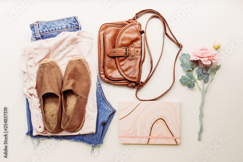 Ideal clothes for summer outfits: a shirt, jeans, a bag, shoes. View from above.