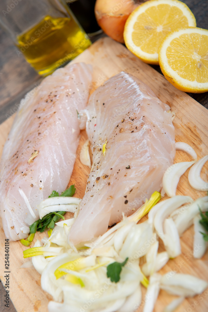 Fresh fish, raw cod fillets with addition of herbs and lemon Fresh fish, raw cod fillets with addition of herbs and lemon