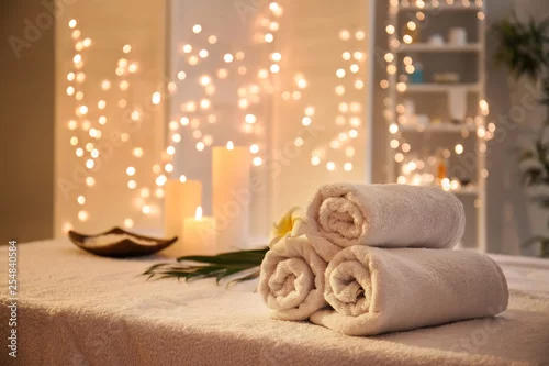 Fototapeta na wymiar Zwinięte ręczniki na stole w salonie spa