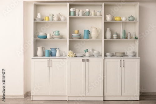 Cupboard with clean dishes in kitchen