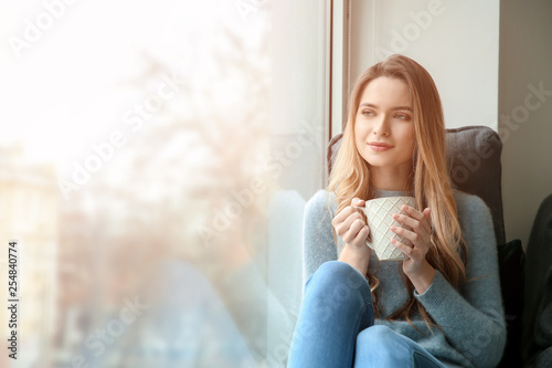 Beautiful young woman drink...
