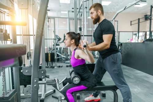 Personal fitness trainer coaching and helping client woman making exercise in gym. Sport, teamwork, training, people concept. © Valerii Honcharuk