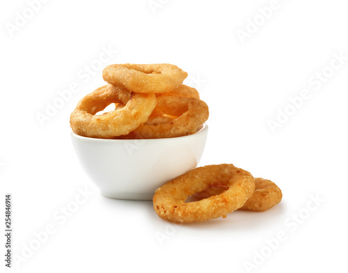 Bowl with tasty onion rings on white background photo