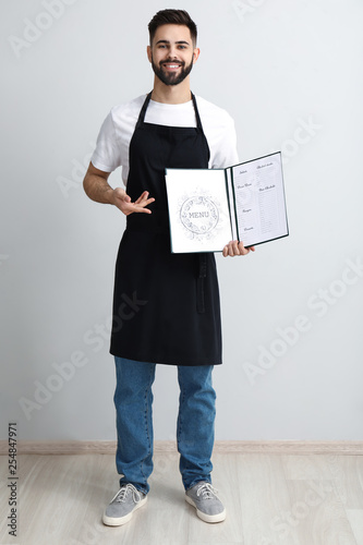 Handsome waiter with menu n...