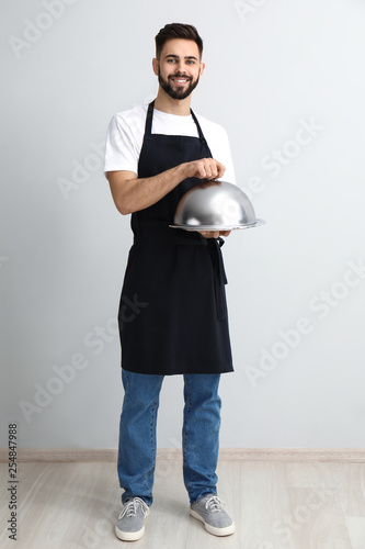 Handsome waiter with tray a...