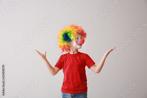 Little boy in funny disguise on light background. April fool s day celebration