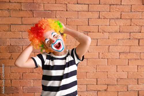 Canvastavla Cute little boy with clown makeup against brick wall
