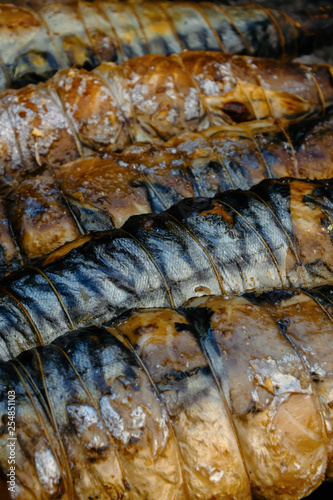 BBQ, grill, kebab. Mackerel fish strung on wooden sticks and tied with string. Close-up.