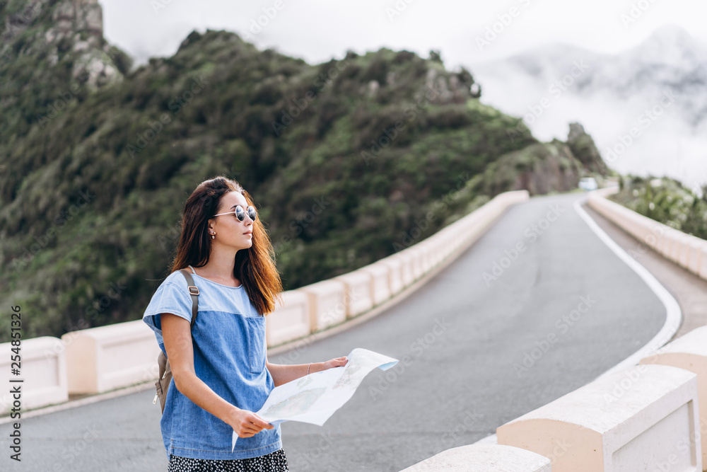 Pretty brunette girl in sunglasses outdoor in the mountains with map. Pretty brunette girl in sunglasses outdoor in the mountains with map.