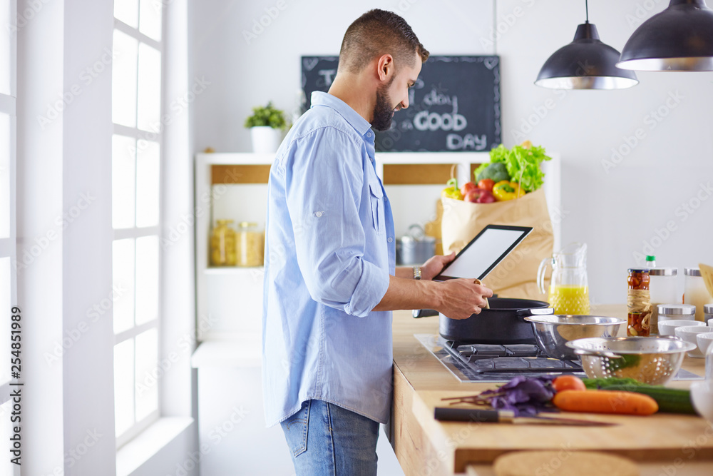 Smiling and confident chef standing in large kitchen Smiling and confident chef standing in large kitchen