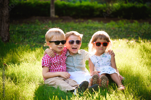 Smiling kids at the garden in sunglasses © nagaets