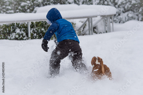 Kid Plays with his dog in deep snow, winter