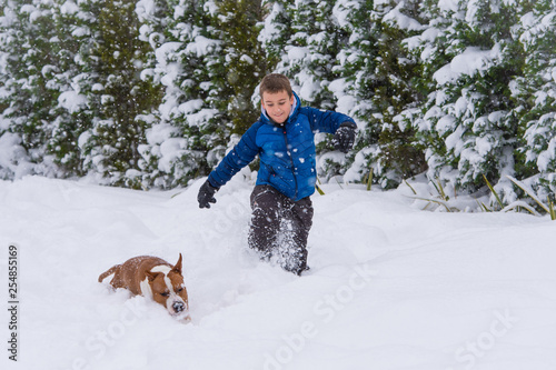 Kid Plays with his dog in deep snow, winter