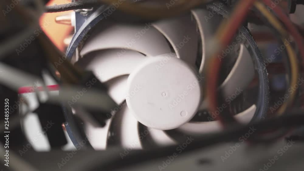 Closeup of worker removing dust from cooling fan in computer case using compressed air Closeup of worker removing dust from cooling fan in computer case using compressed air