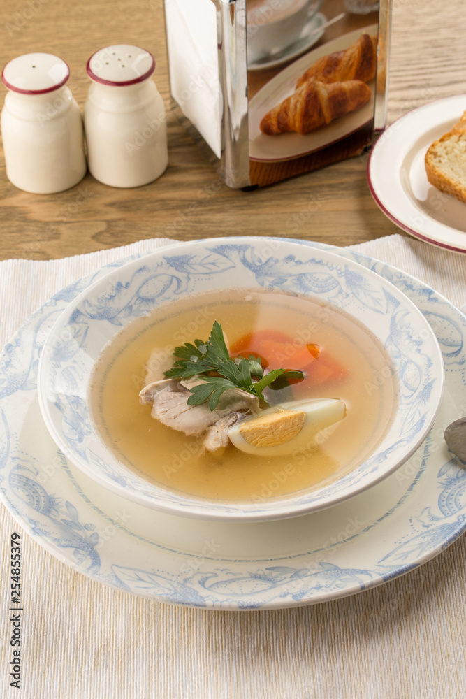 Dietary soup with chicken and egg on wooden table