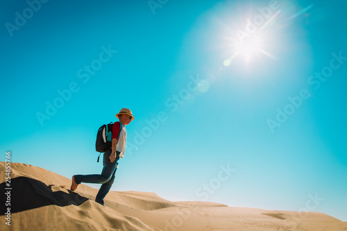 happy young boy walk in sand dunes
