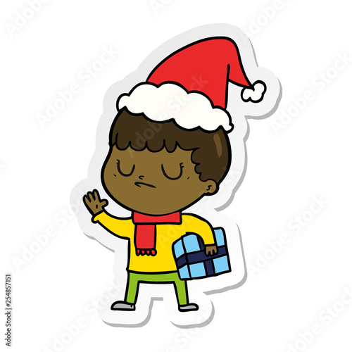 sticker cartoon of a grumpy boy wearing santa hat