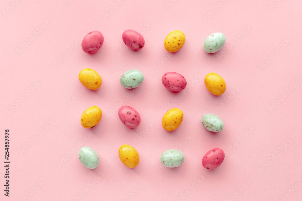 Easter chocolate eggs candy on a pastel pink background, creative flat lay easter concept, top view Easter chocolate eggs candy on a pastel pink background, creative flat lay easter concept, top view