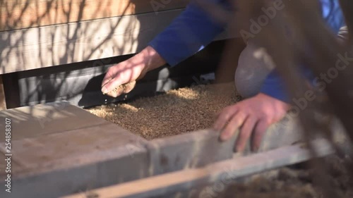 Mann streut Sand als Untergrund