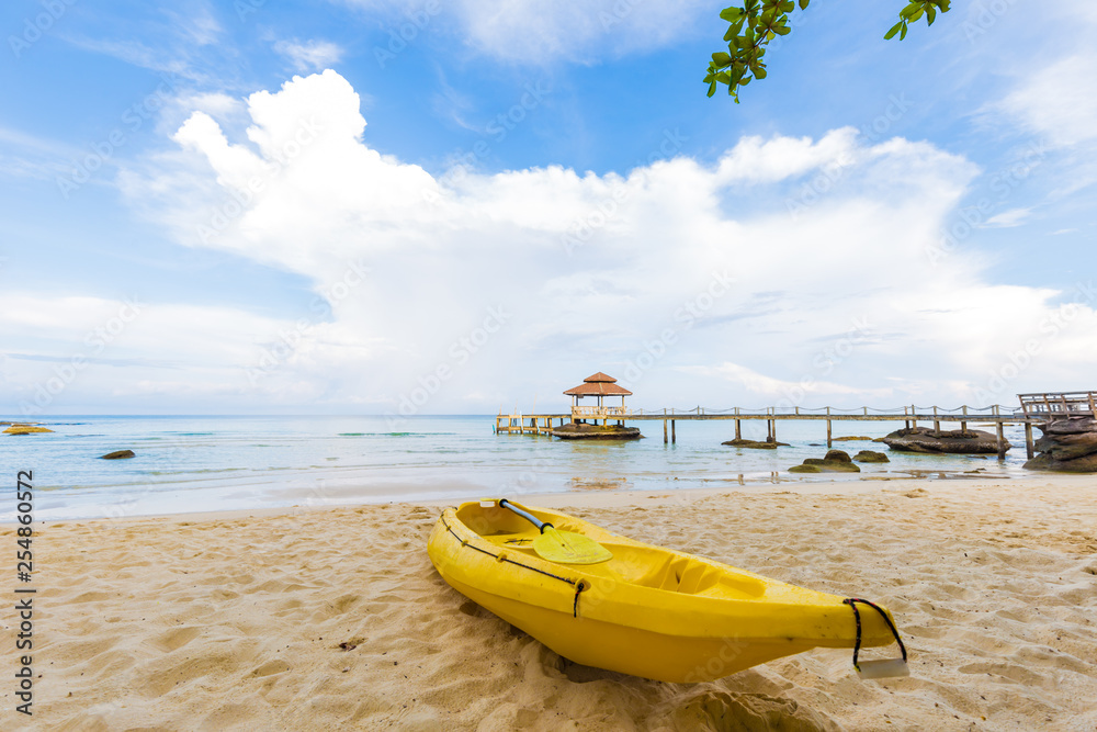 Fototapeta premium Yellow kayak boat on white sand beach