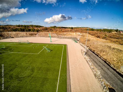 Aerial view of green artificial grass on the field. Shot from the drone. photo