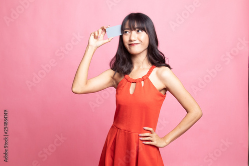 Young Asian woman think with a blank card. © halfbottle