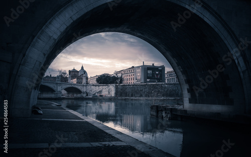 Photo taken from he bank of the river Tiber looking under the bridge towards the Vatican taken late afternoon to give a moody finish to the image.  © Keith Newman