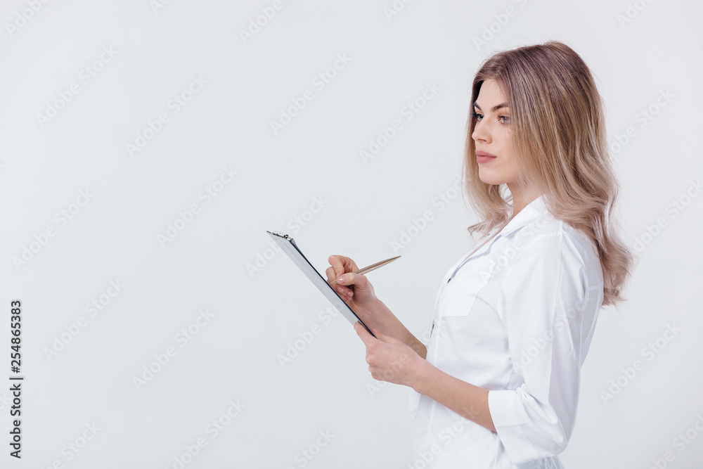 Medical physician doctor woman in white coat holding folder and filling out prescription on light background. Medical physician doctor woman in white coat holding folder and filling out prescription on light background.
