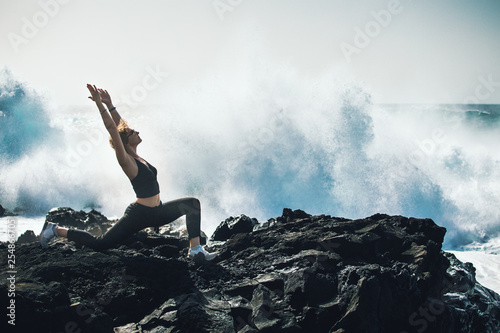 Girl doing yoga on the ocean.