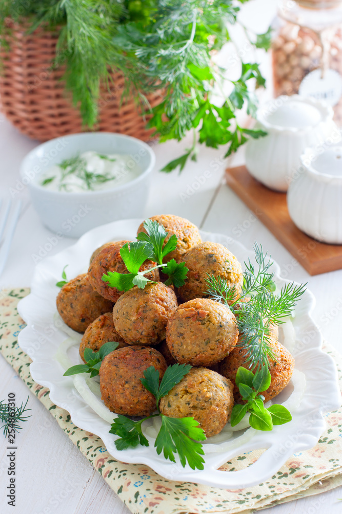 Chickpea falafel with fresh herbs on a white plate, selective focus