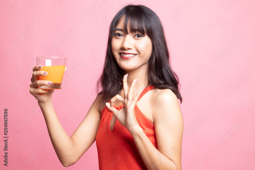 Young Asian woman show OK drink orange juice. Young Asian woman show OK drink orange juice.