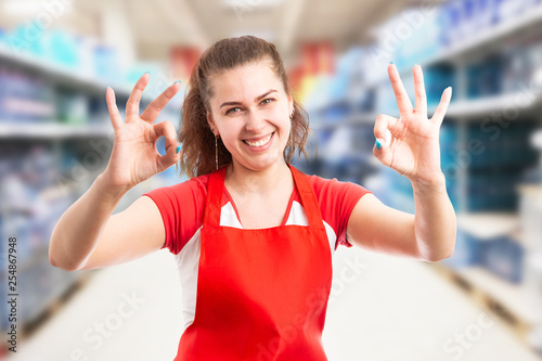 Female employee at hypermarket making okay gesture.