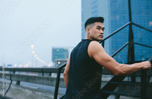 Muscular man climbing up steps outdoors
