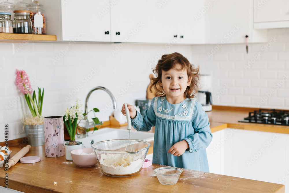 Little girl preparing easter cookies at the kitchen. Little girl preparing easter cookies at the kitchen.