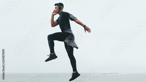 Sporty man exercising jump and lunge
