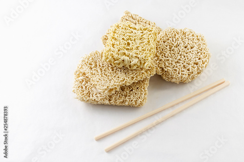 Heap of different Asian raw dried egg noodles on white background