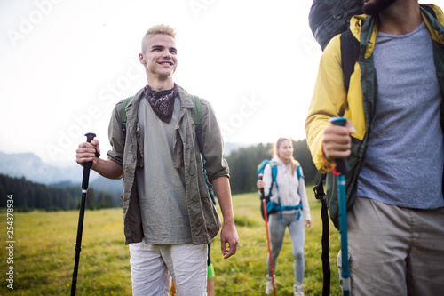 travel, tourism, hike, gesture and people concept - group of smiling friends with backpacks
