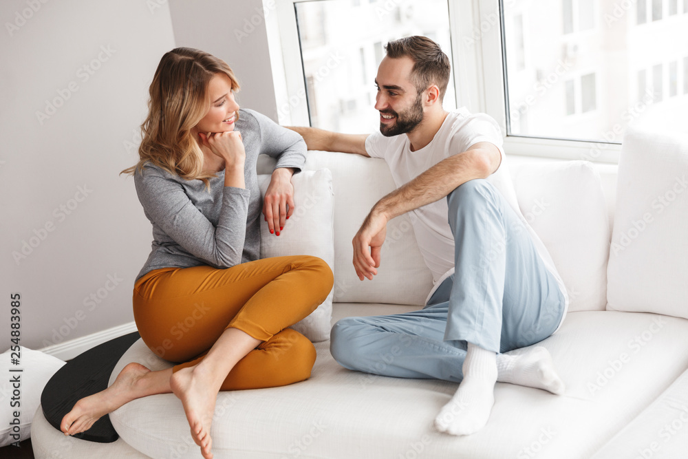 Young cute loving couple indoors at home talking with each other. Young cute loving couple indoors at home talking with each other.