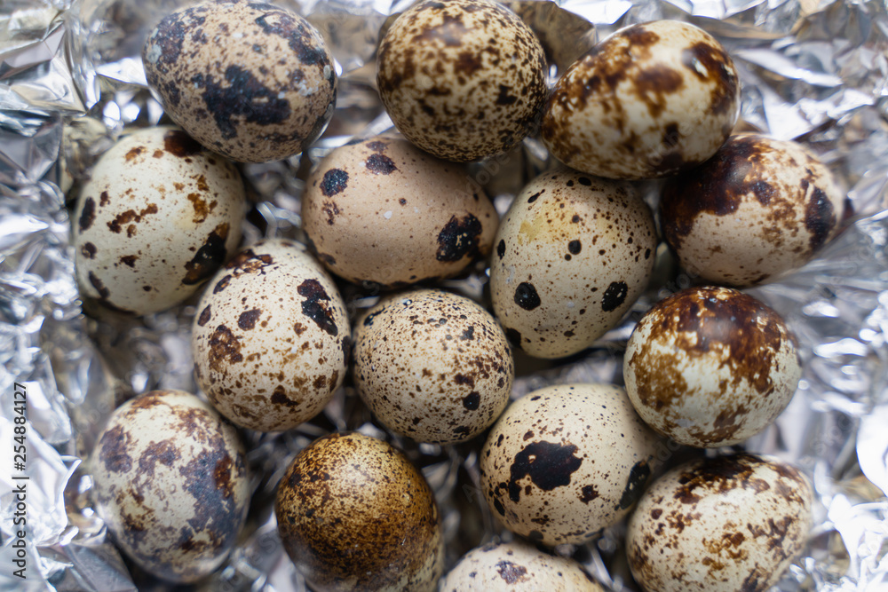 quail eggs on silvery crumpled surface close up as background quail eggs on silvery crumpled surface close up as background